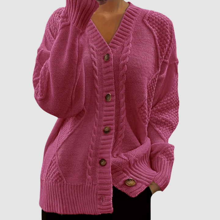 Hot pink button-up sweater with textured patterns, worn by a model; studio background.