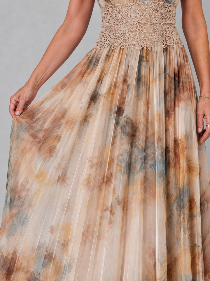 Close-up of flowing floral pattern skirt with lace waist detail in earthy colors, held by a woman in a studio setting.