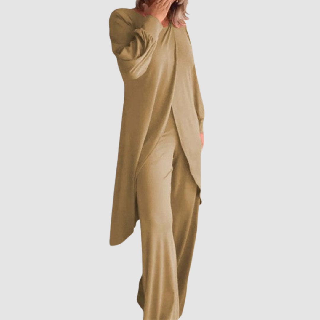 Model wearing a beige long-sleeve 2-piece set in a studio, hand covering face, white background.