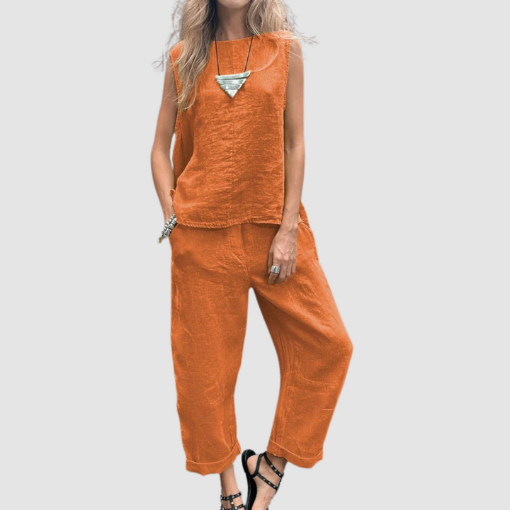 Vibrant orange two-piece summer set with sleeveless top and loose pants, worn by model, gray background.