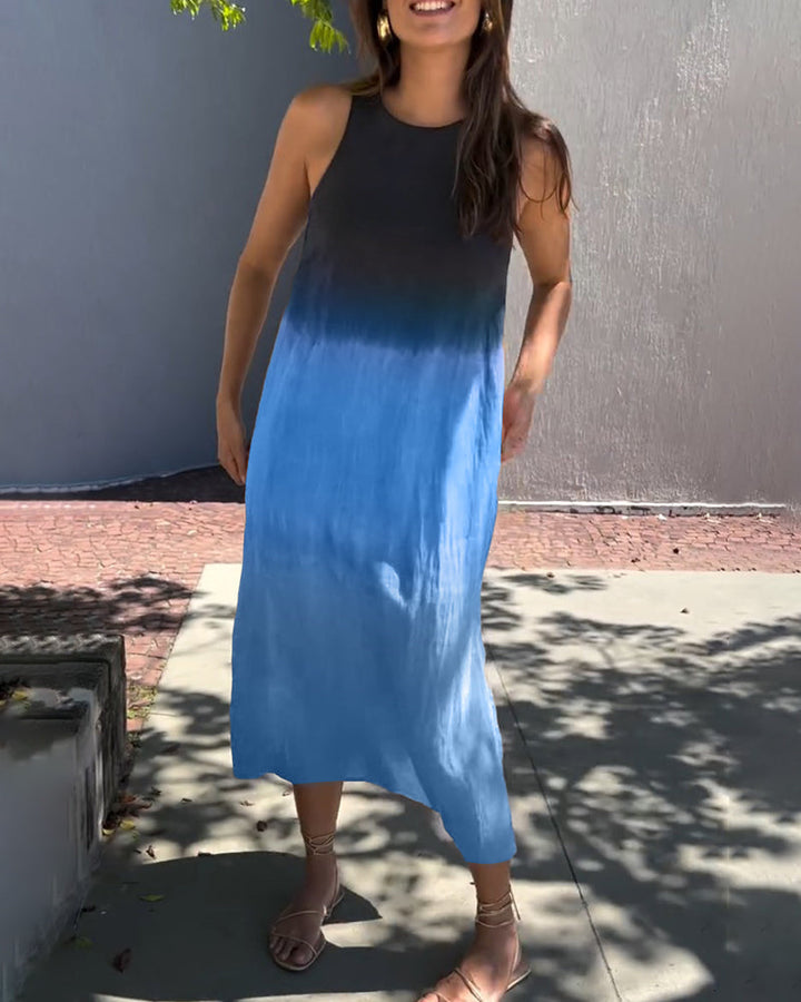 Woman wearing ombre black to blue sleeveless dress standing in a sunny outdoor area.