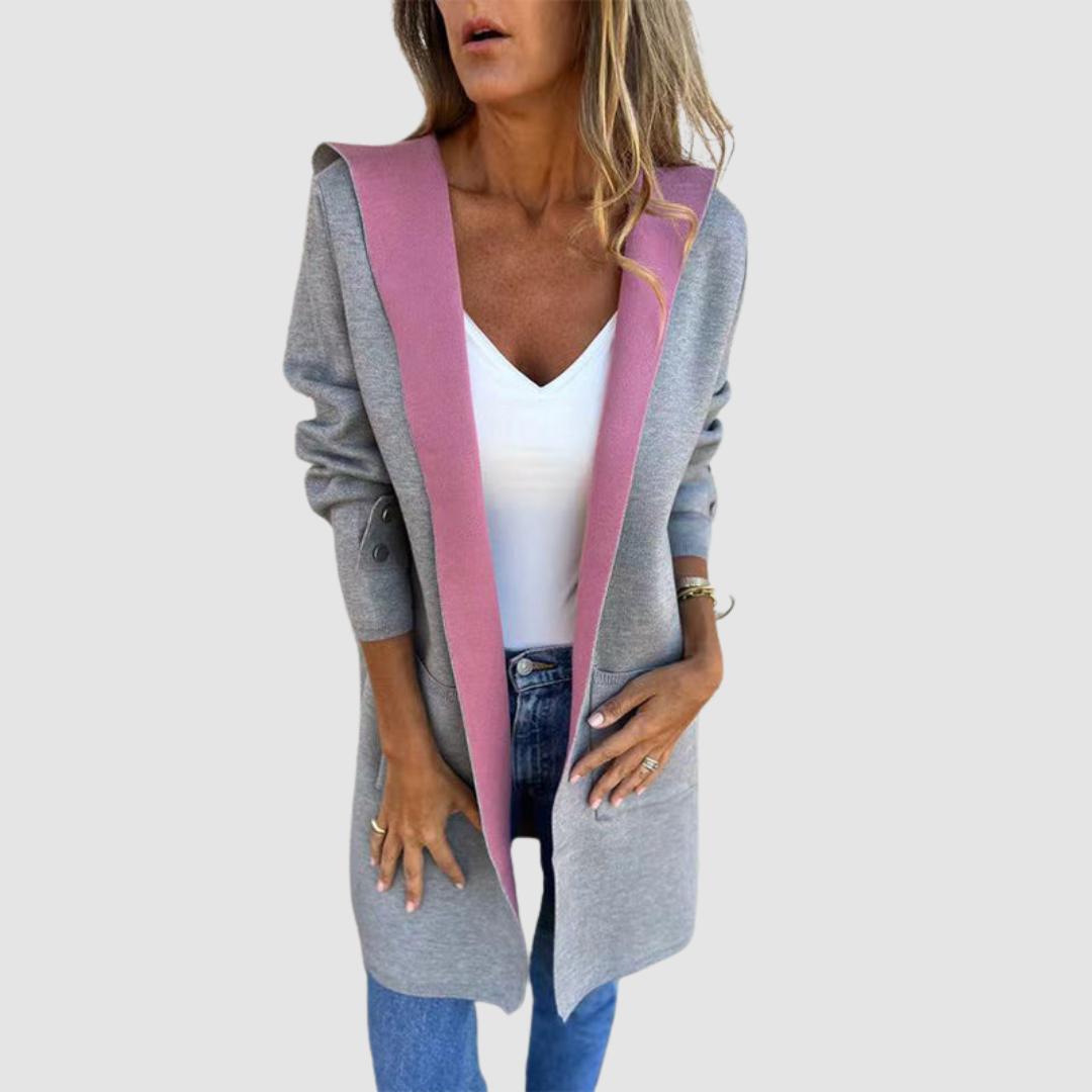 Gray and pink colorblock hooded jacket worn over white top and jeans in a studio setting.