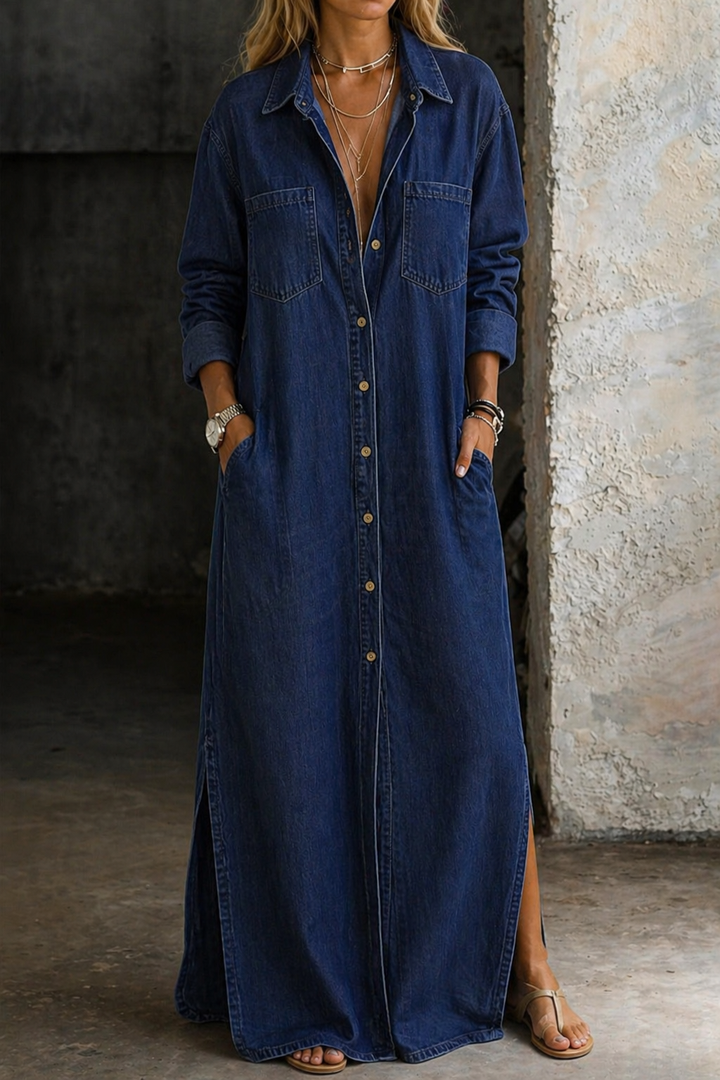 Dark blue denim button-down dress with side slit, rolled sleeves, in an industrial setting.