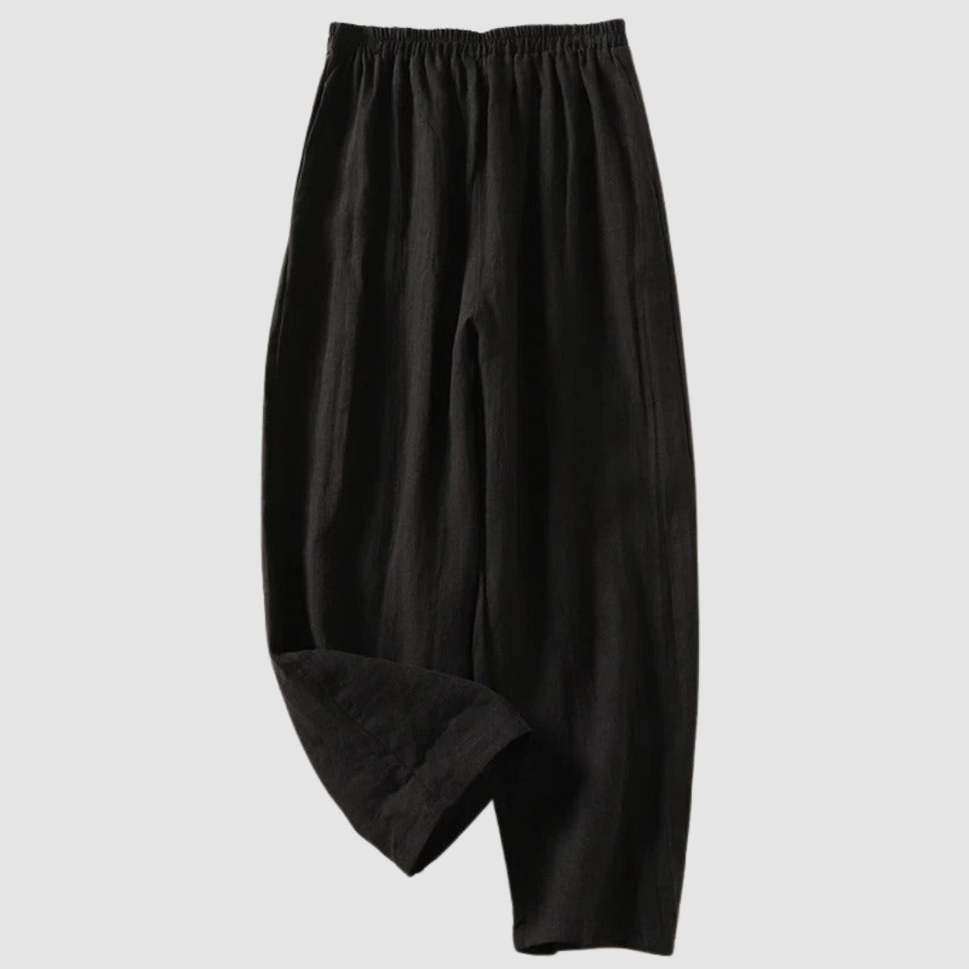 Black relaxed-fit pants with elastic waistband, styled on a light gray background.