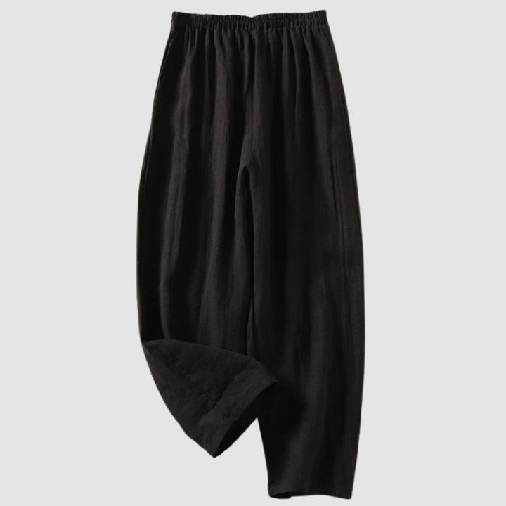 Black relaxed-fit pants with elastic waistband, styled on a light gray background.