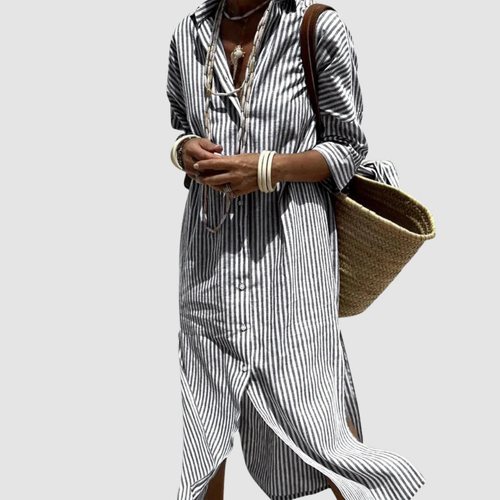 Model in a black striped button-down summer dress with a wicker bag, studio setting.