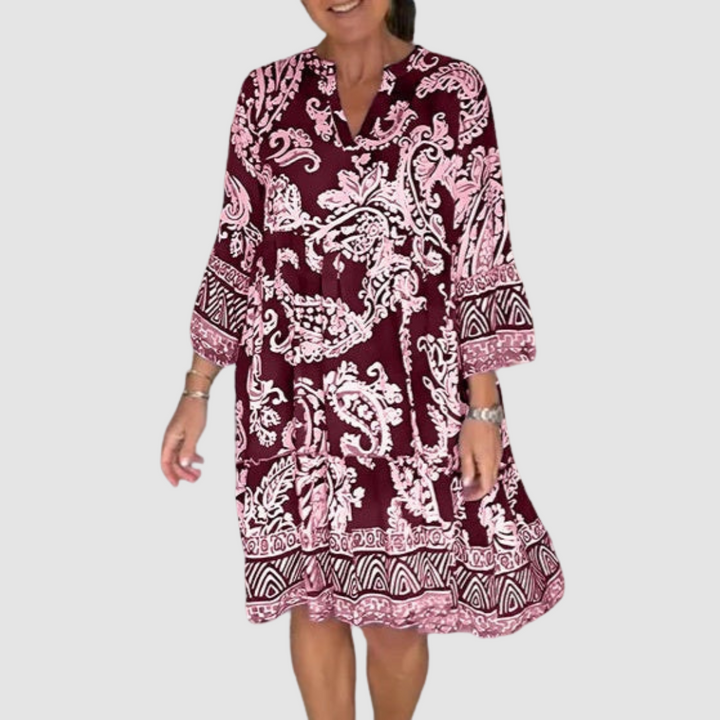 Maroon, pink paisley V-neck dress with 3/4 sleeves in a studio setting.