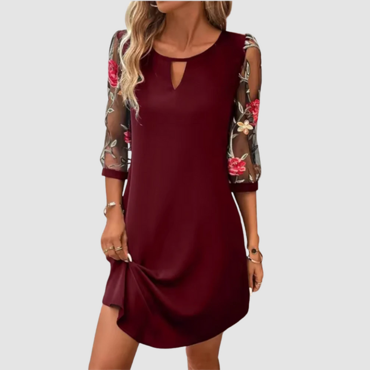 Burgundy summer dress with floral print sheer sleeves, shown indoors with a plain backdrop.