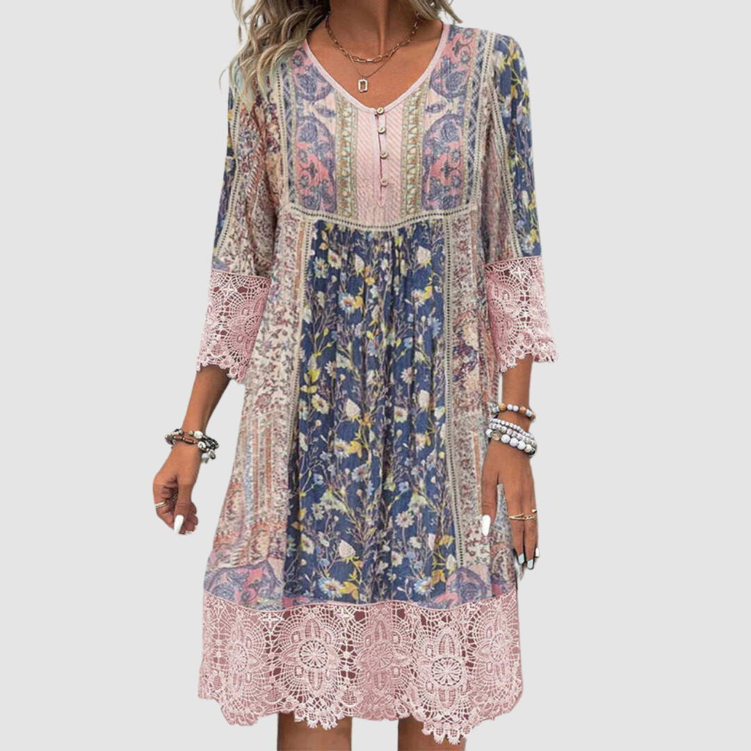 Boho dress with colorful floral pattern and lace trim, worn by model, shown from the front against a plain backdrop.