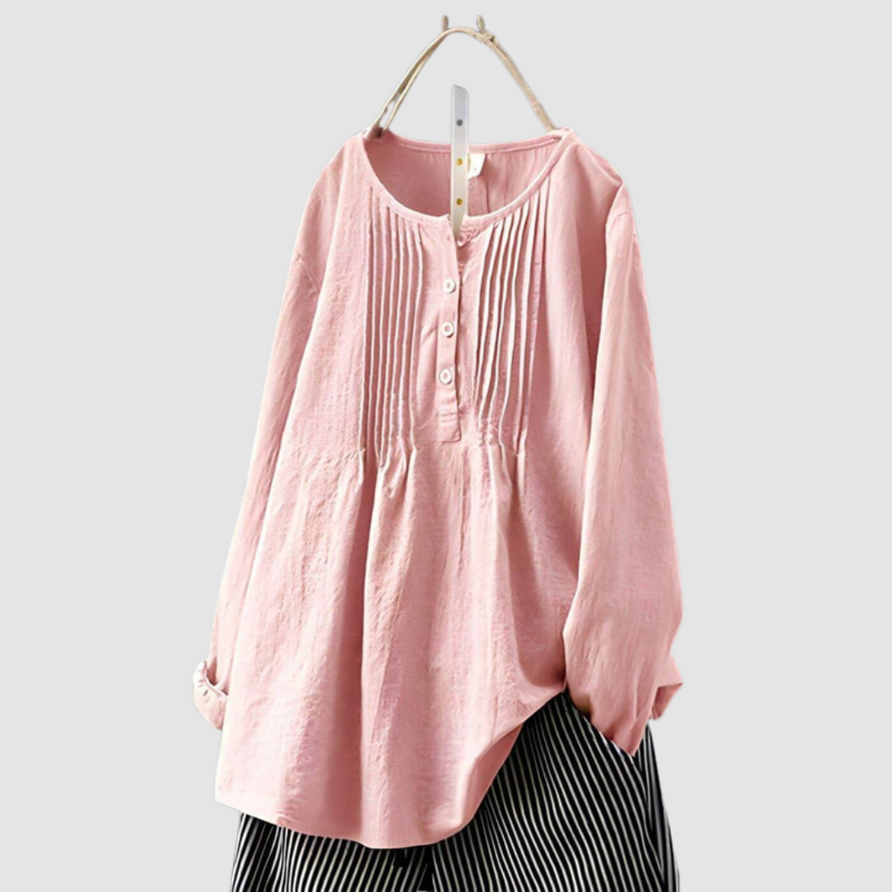 Chic light pink blouse with pleated front and button details, displayed on a hanger against a plain background.