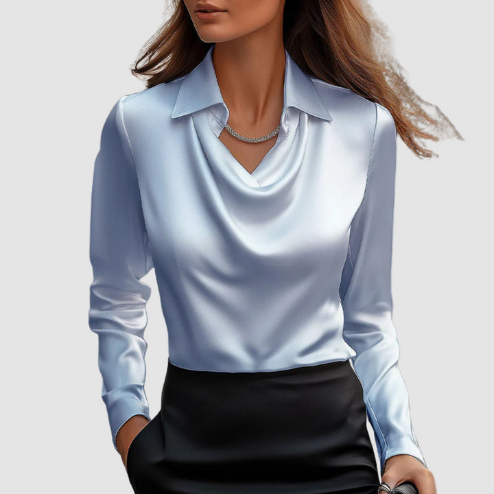 Elegant light blue satin blouse with a draped neckline and long sleeves set against a plain gray background.