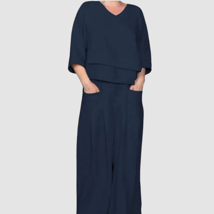 Navy relaxed 2-piece set with V-neck top and wide-leg pants featuring pockets, studio background.