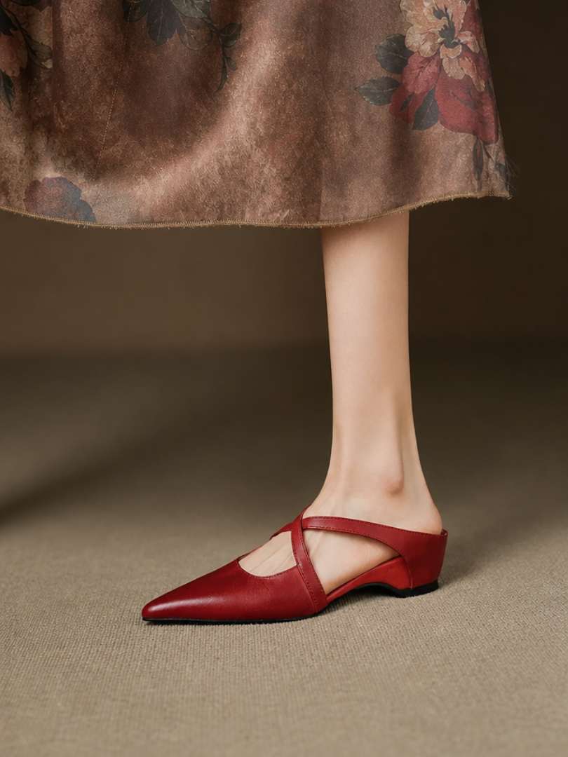 Red pointed mules with criss-cross straps worn with a floral skirt.