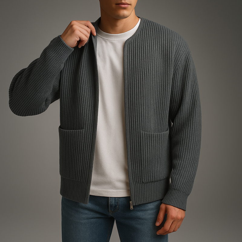 Model in a dark gray knit zip cardigan over a white shirt and jeans in a studio.