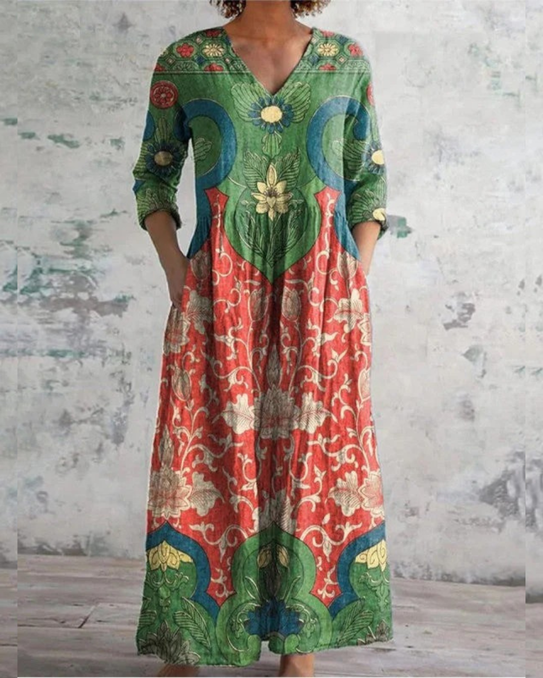 Colorful vintage floral dress with intricate patterns against a textured, rustic indoor backdrop.