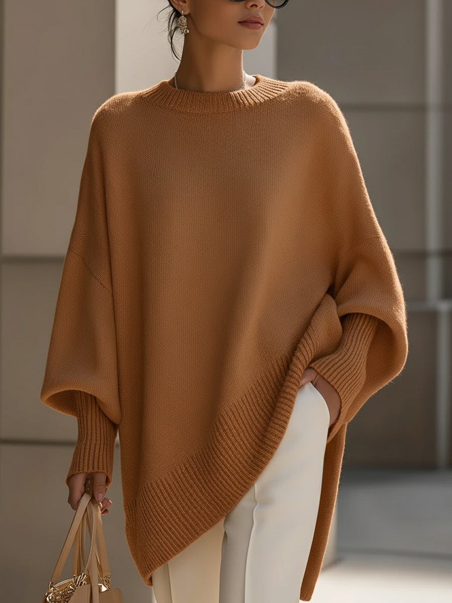 Woman in an oversized orange sweater with ribbed hem and cuffs, holding a bag, in an urban setting.