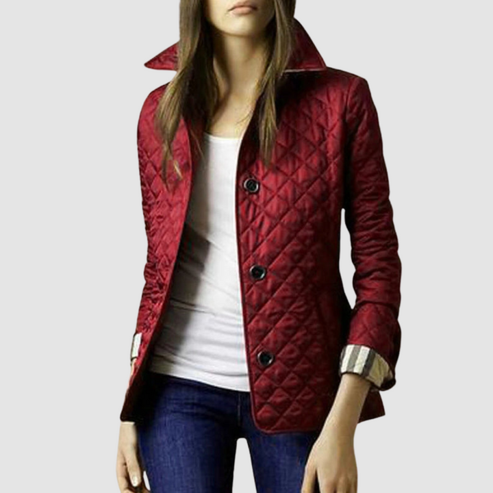 Deep red quilted jacket with buttons, worn with a white top and jeans on a model, light background.