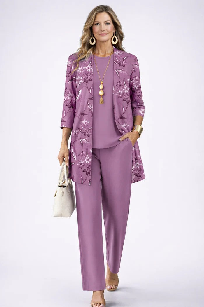 Woman wearing a lavender floral three-piece set with a matching necklace. White studio background.