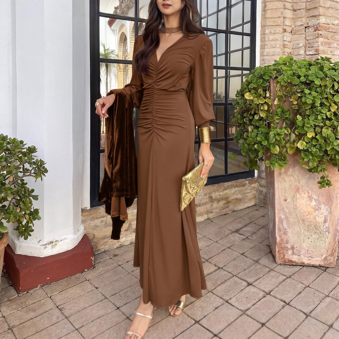 Classic brown midi dress with ruched front and long sleeves, gold accessories complement the look, on a scenic patio.