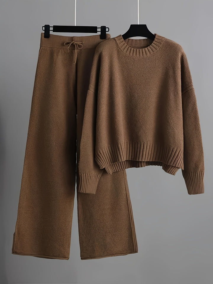 Brown knit loungewear set with a cozy sweater and drawstring pants on hangers, gray background.