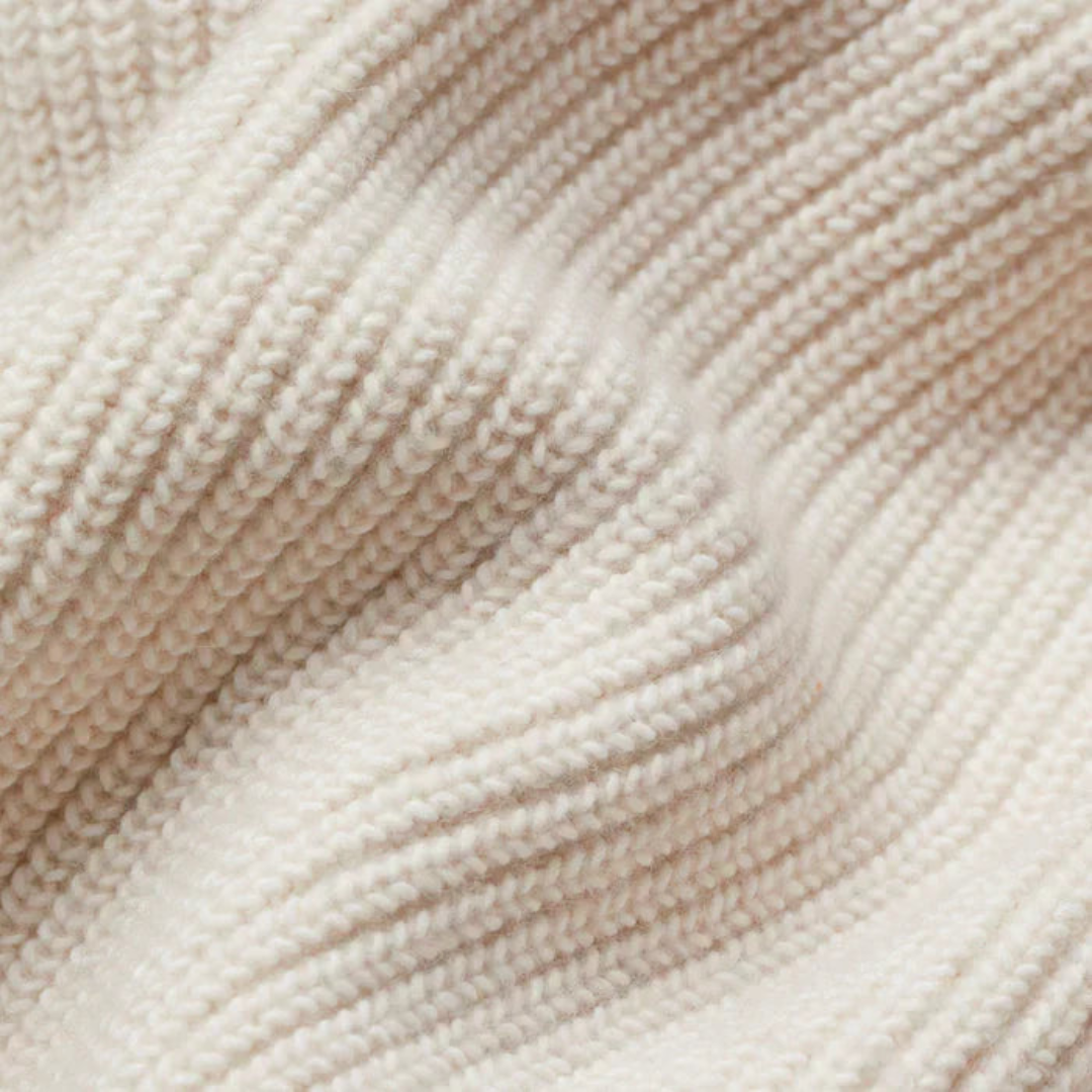 Detailed close-up of soft, textured, white knit fabric in a folded arrangement.