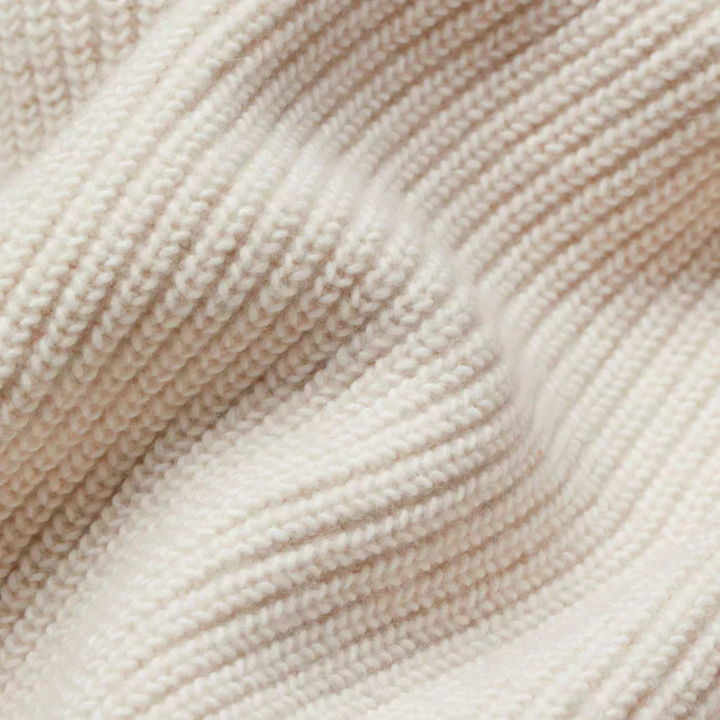 Detailed close-up of soft, textured, white knit fabric in a folded arrangement.