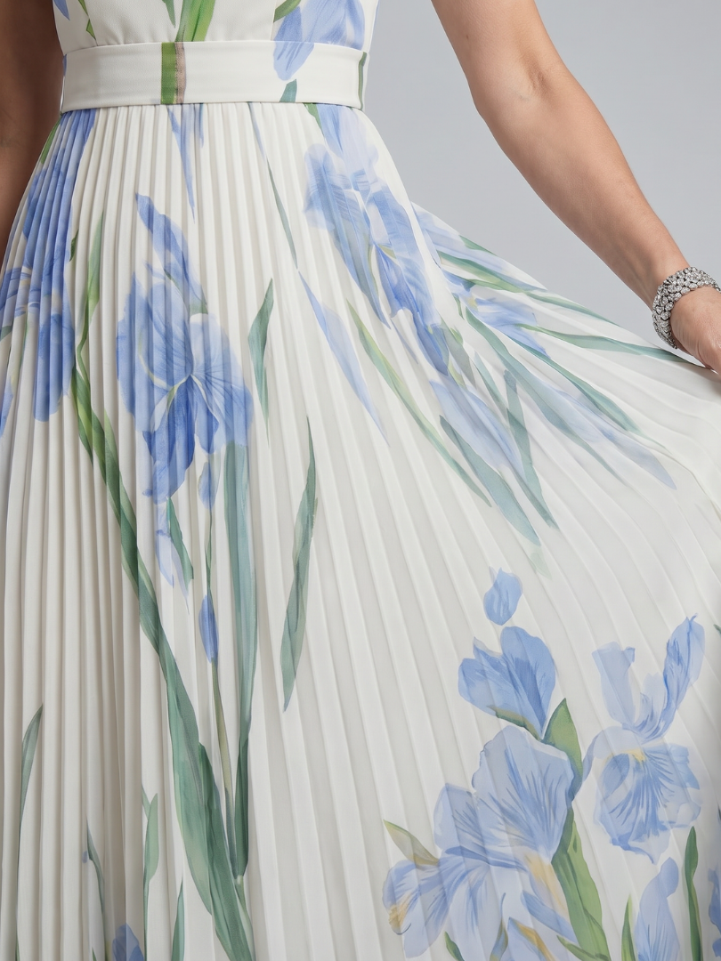 Close-up of floral print on flowing midi dress, studio background.