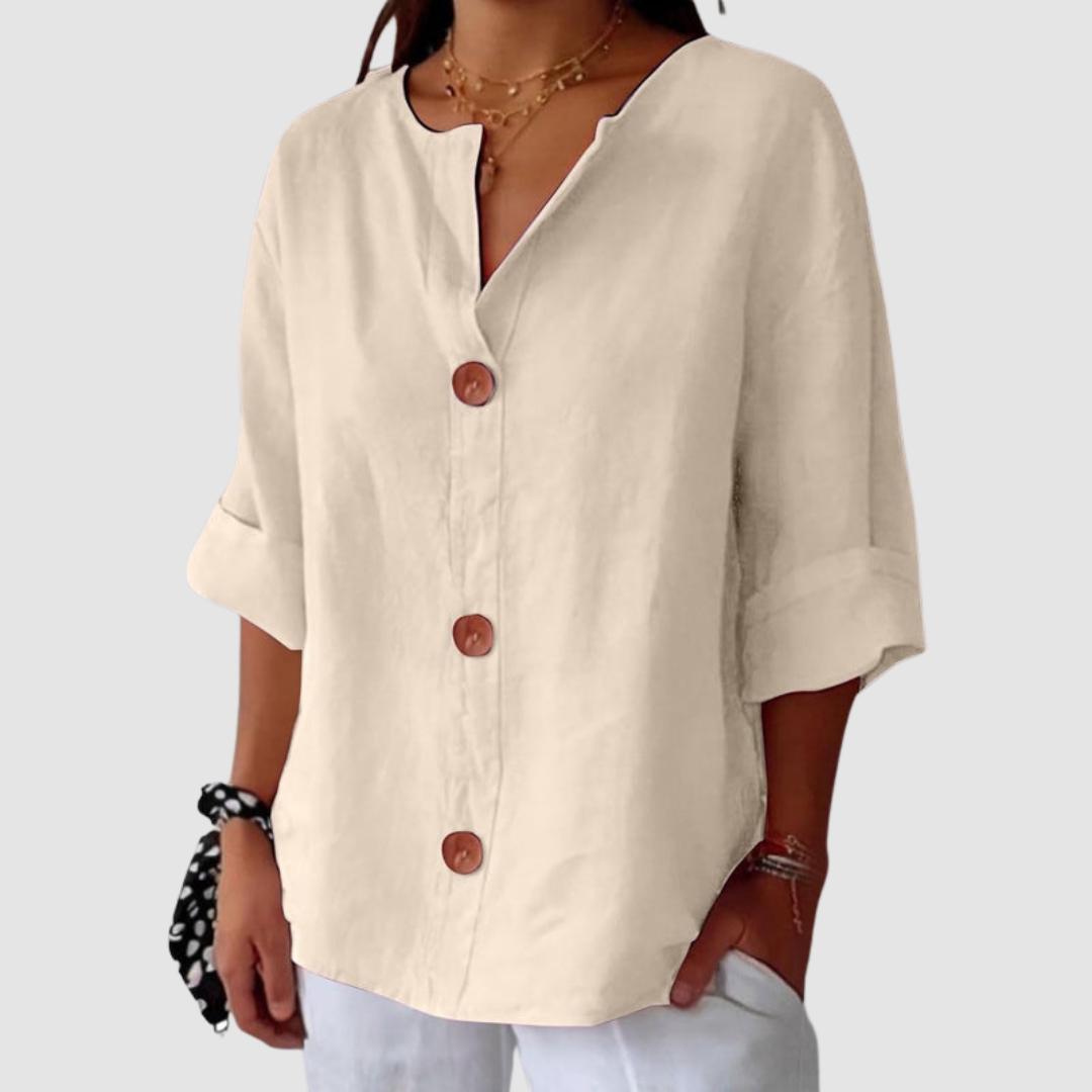 Cream casual blouse featuring a relaxed fit and button details, set on a white backdrop.