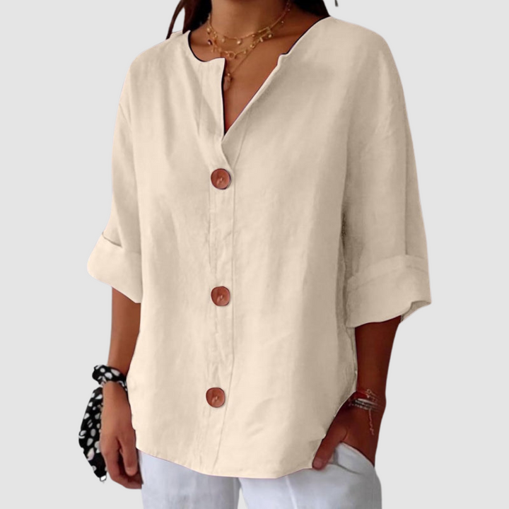 Cream casual blouse featuring a relaxed fit and button details, set on a white backdrop.
