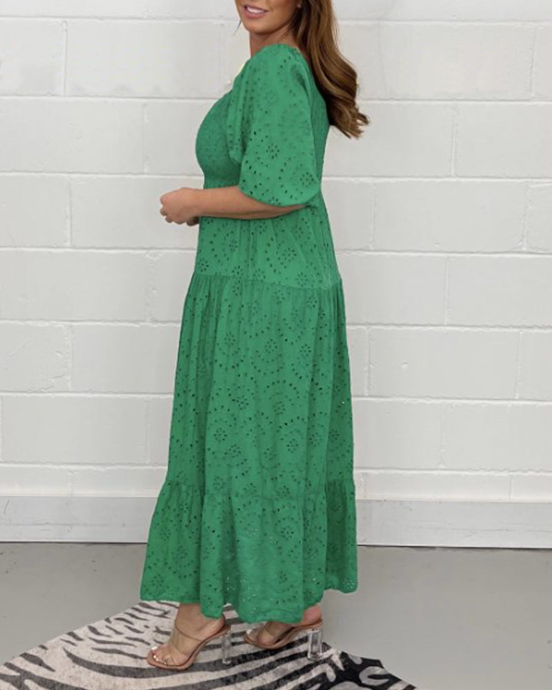 Side view of green dress with eyelet detail, showcased in a minimalist indoor setting.