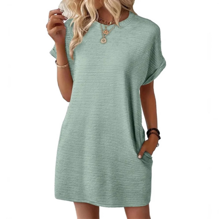 Light mint green casual dress featuring short sleeves and an easy fit, styled with necklaces in a studio background.