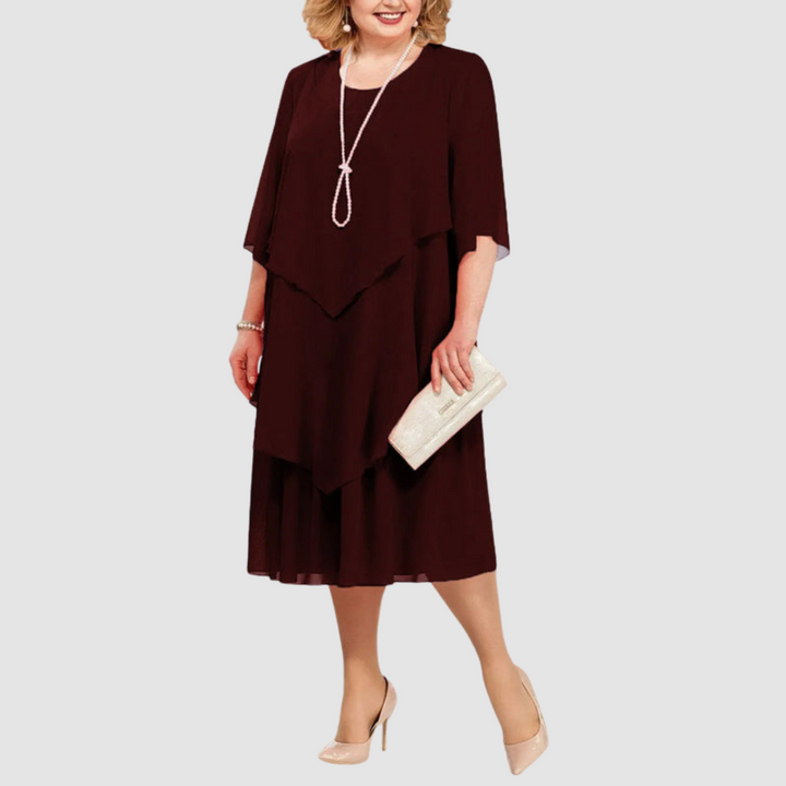 Burgundy chiffon midi dress with layered style, accessorized with pearl necklace and beige clutch, against white background.