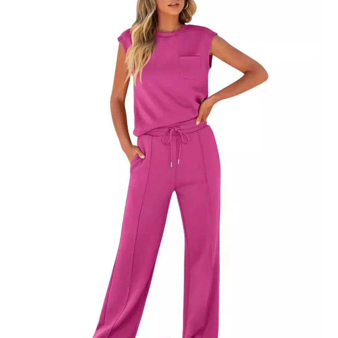 Pink casual lounge set with sleeveless top and drawstring pants, studio setting.