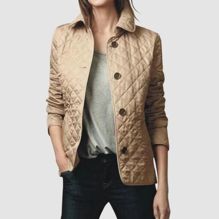 Beige quilted jacket with buttons, worn over gray top and jeans by a model, light background.