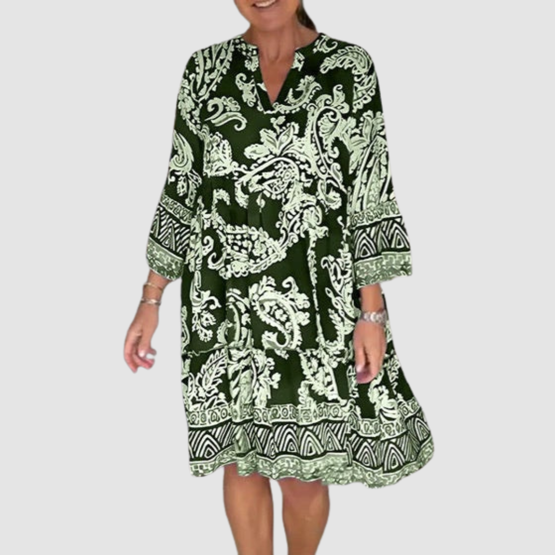 Green, white paisley V-neck dress with 3/4 sleeves in a studio setting.
