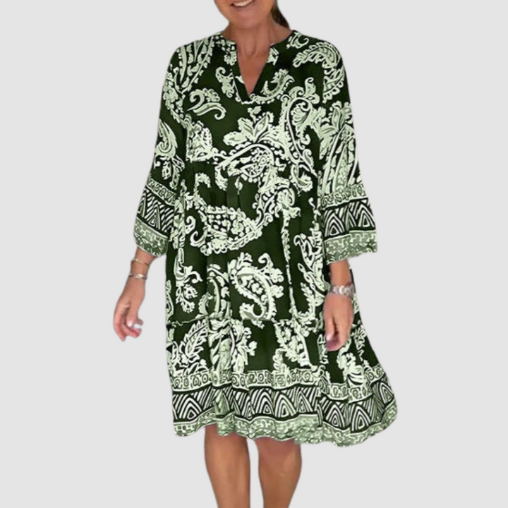 Green, white paisley V-neck dress with 3/4 sleeves in a studio setting.