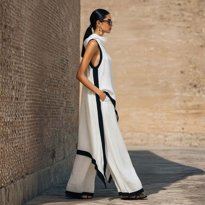 Side view of elegant white outfit with black trim, worn by a person with sunglasses, outdoor brick wall backdrop.