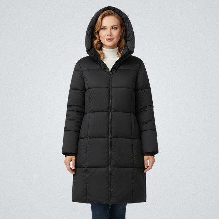 Woman in a black puffer coat with hood, paired with a white turtleneck, against a white background.