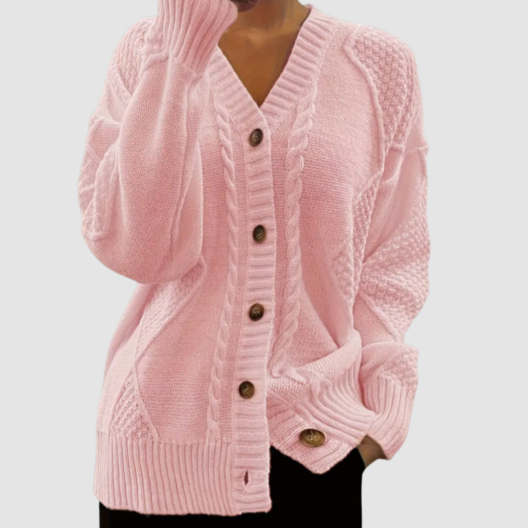 Light pink button-up sweater with textured patterns, worn by a model; studio background.