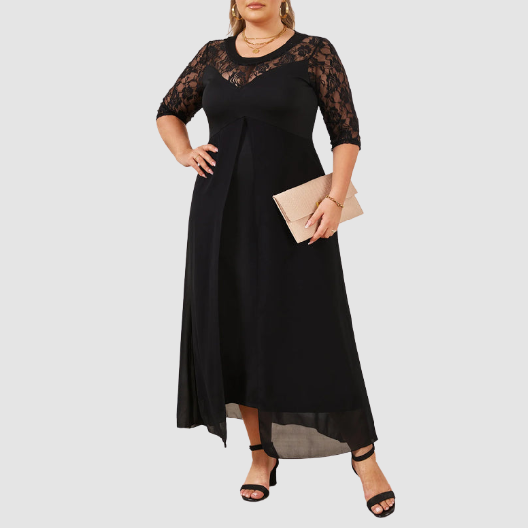 Long black dress with lace sleeves and neckline, worn with black heels and a beige clutch. Studio setting.