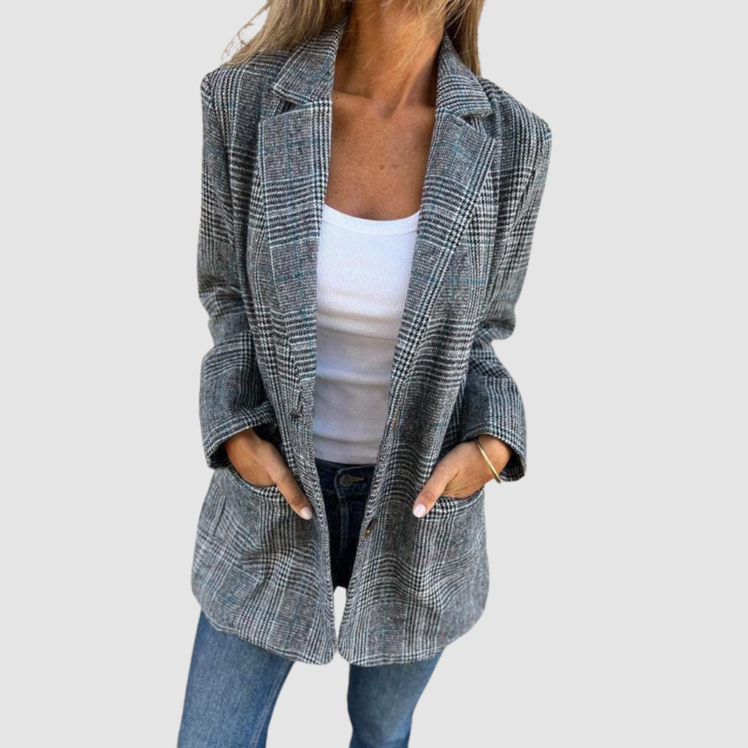 Gray plaid blazer styled with hands in pockets, paired with a white top and jeans, shown in a studio environment.