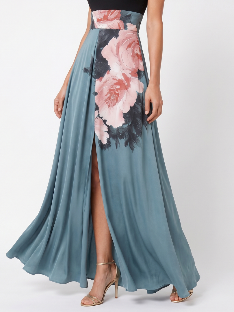 Close-up of floral skirt on maxi dress with black halter bodice, studio setting.