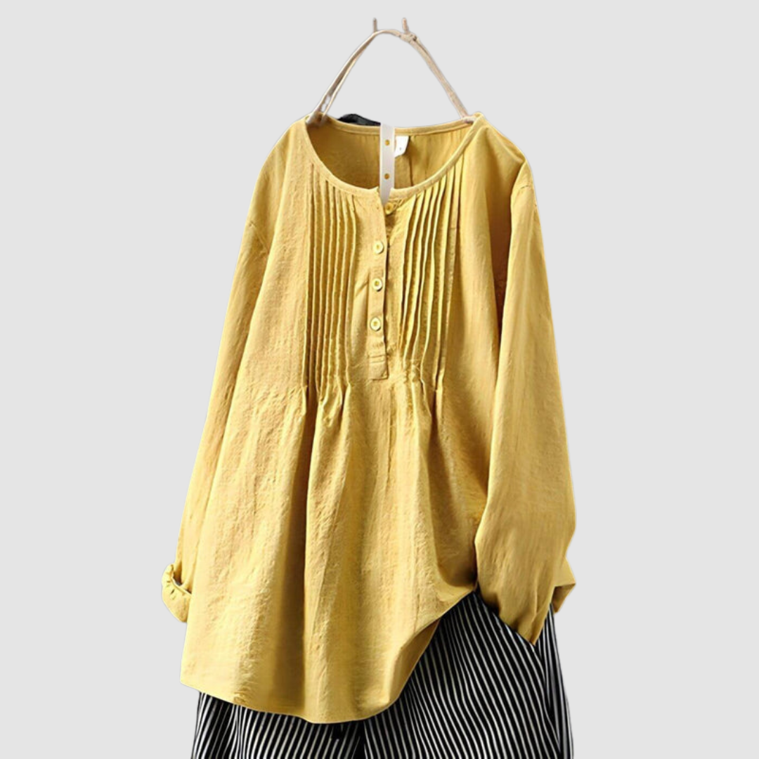 Stylish yellow blouse with pleated front and button accents, displayed on a hanger against a plain background.
