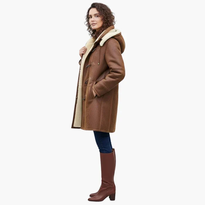 Side profile of brown coat with cream interior, worn by a person. Styled with jeans and tall brown boots. White background.
