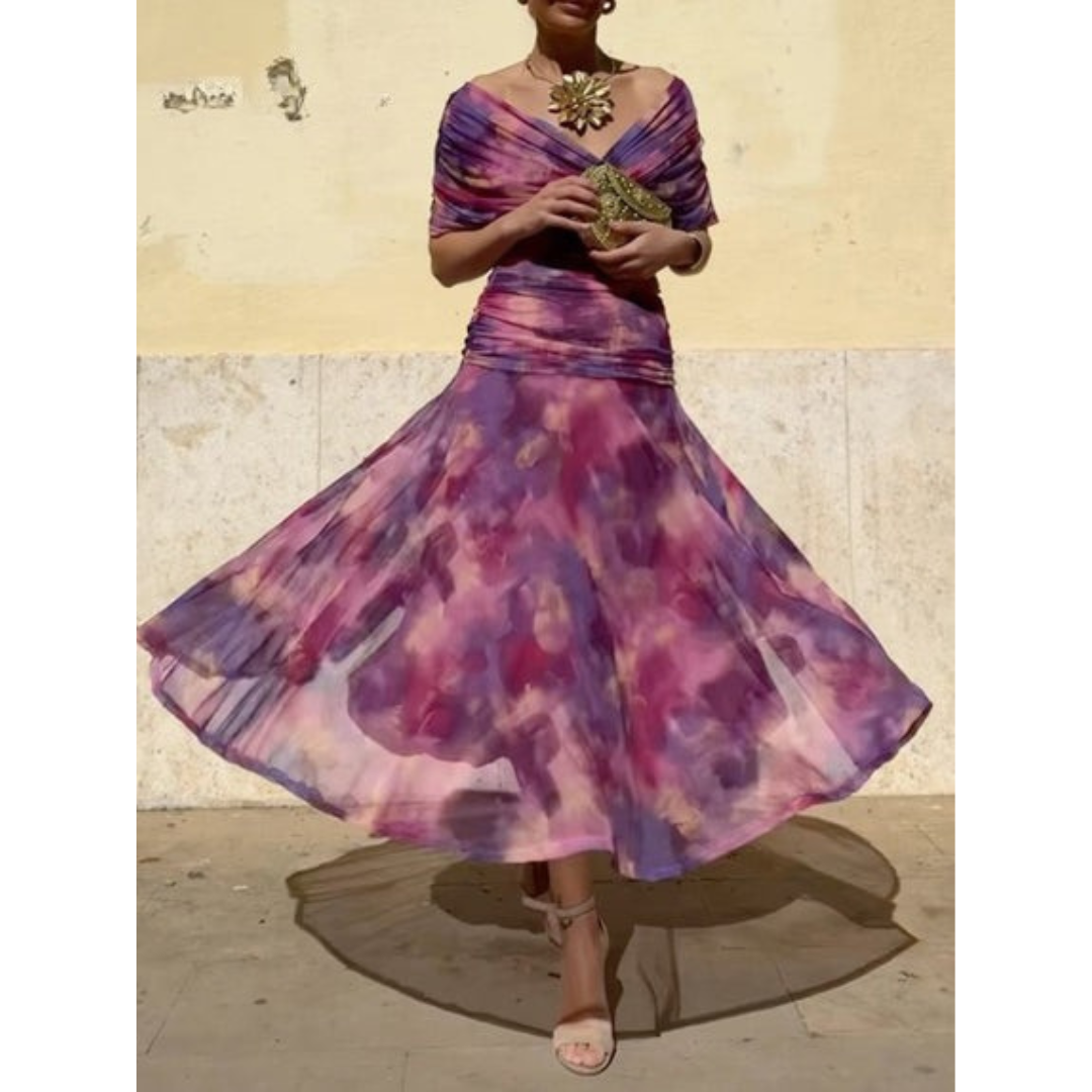 Woman in a flowing, purple floral corset dress twirling in a sunlit outdoor setting with a light-colored wall.