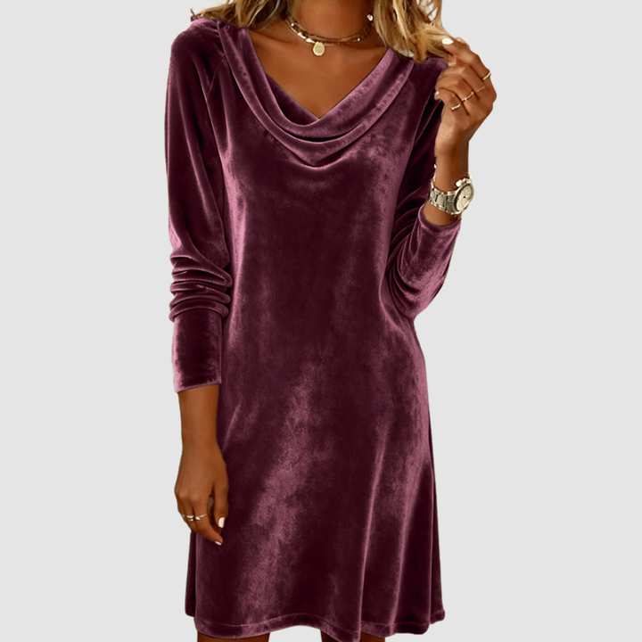 Dark purple velvet long sleeve dress with a draped neckline on a white background.