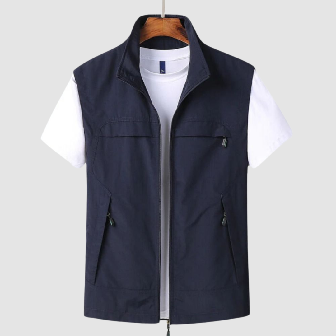 Navy blue summer vest featuring zipped front and pockets, shown over a white t-shirt, on a hanger against a gray background.