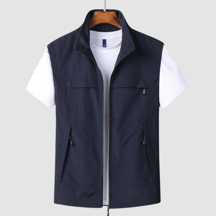 Navy blue summer vest featuring zipped front and pockets, shown over a white t-shirt, on a hanger against a gray background.