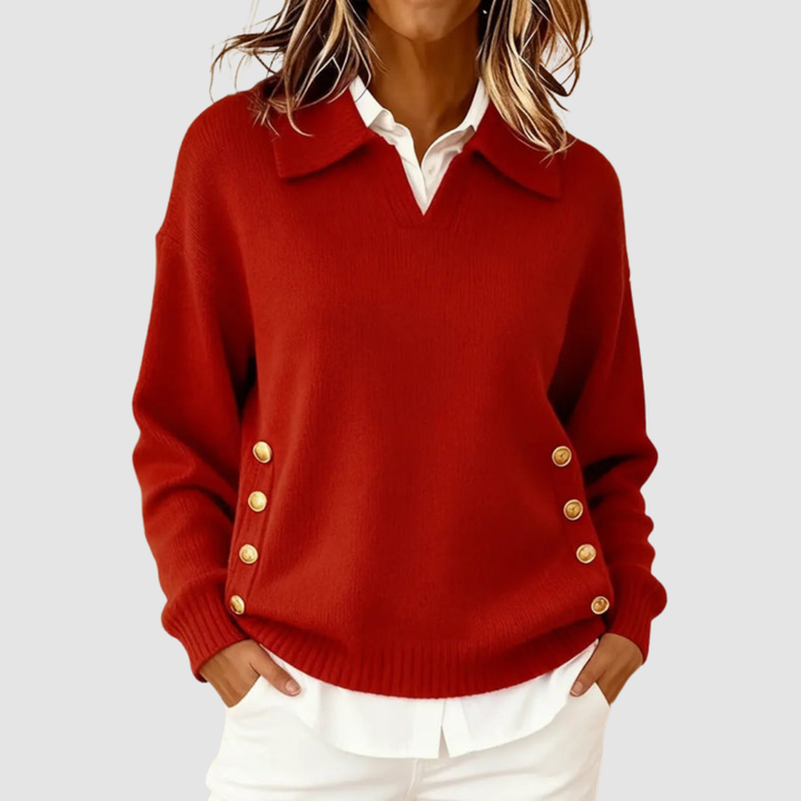Elegant red knitted sweater with gold buttons on sides, worn over a white shirt against a light grey background.