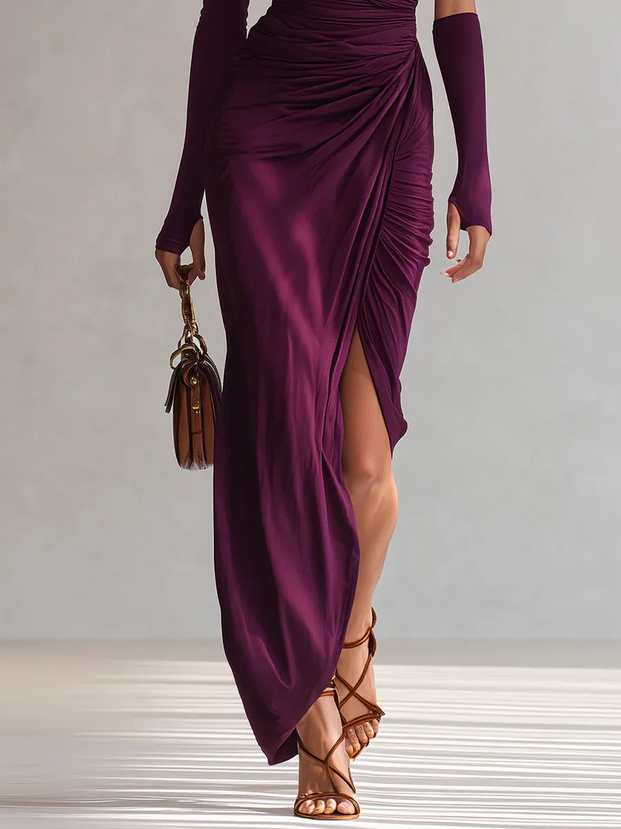 Front view of purple maxi dress with gathered fabric and brown handbag, accented by strappy sandals in studio setting.